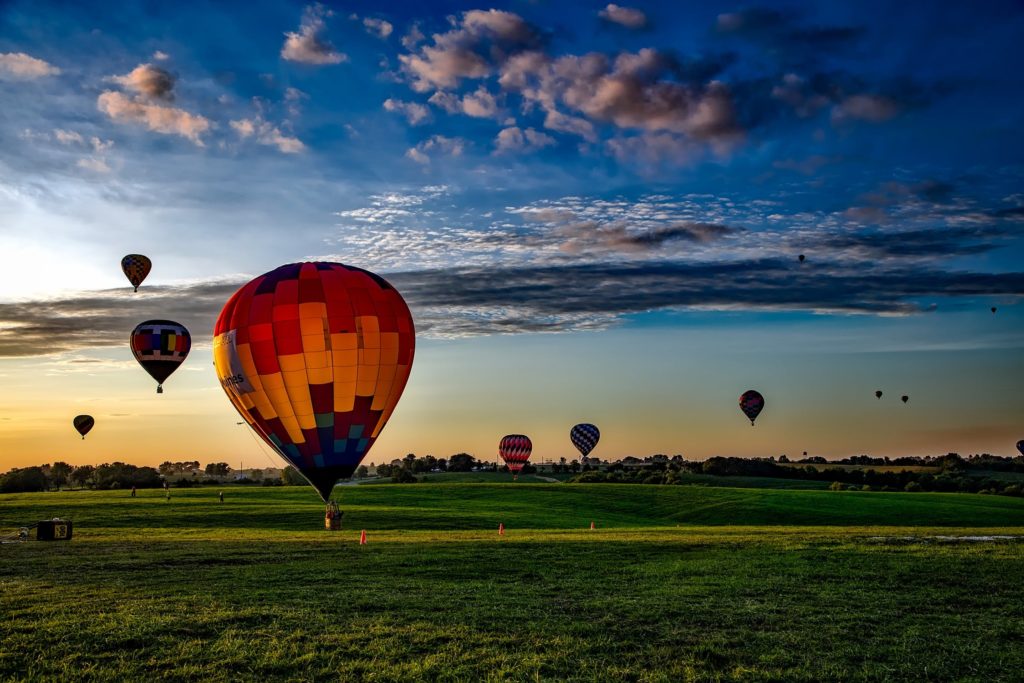 Multiple hot air balloons launching and flying in the sky