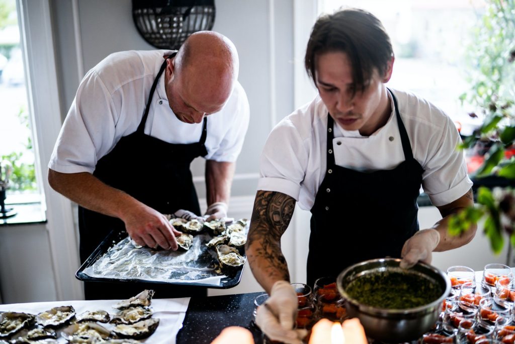 Two chefs preparing a meal in a light kitchen